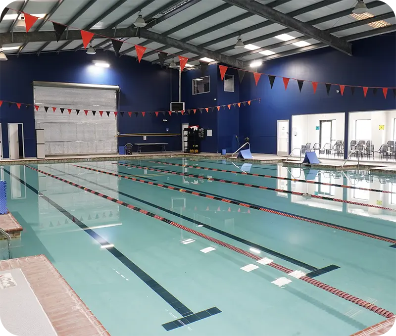A student and instructor practicing professional swim techniques in the Spring, TX, indoor facility.