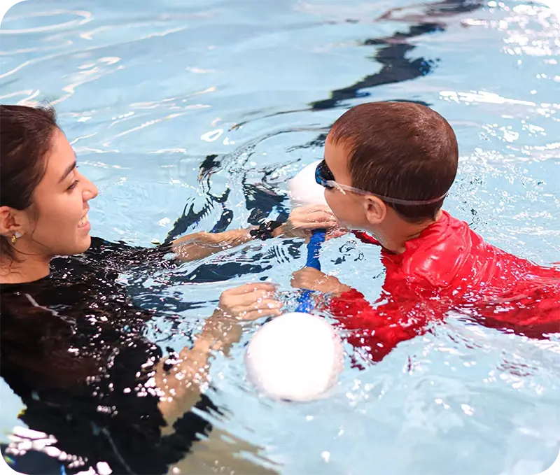 A student and instructor practicing professional swim techniques in the Spring, TX, indoor facility.